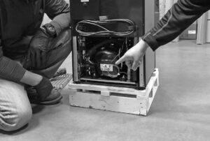 Two workers doing tech support on a cooler