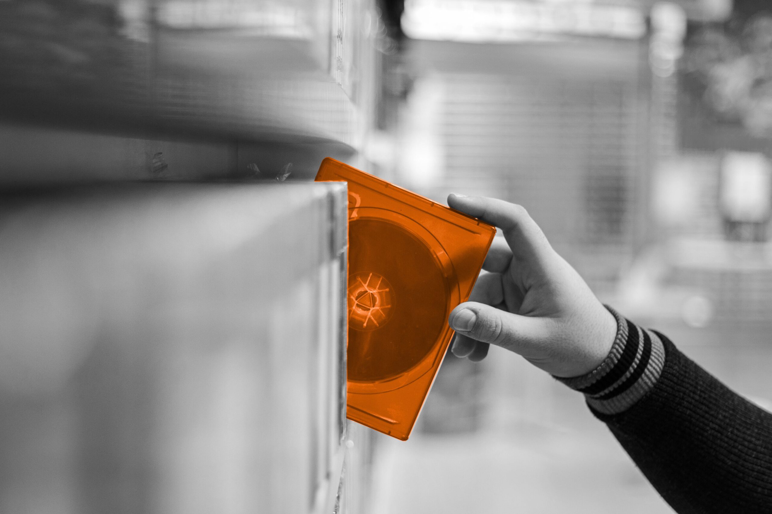 Hand Reaching for a orange disk in a video library.